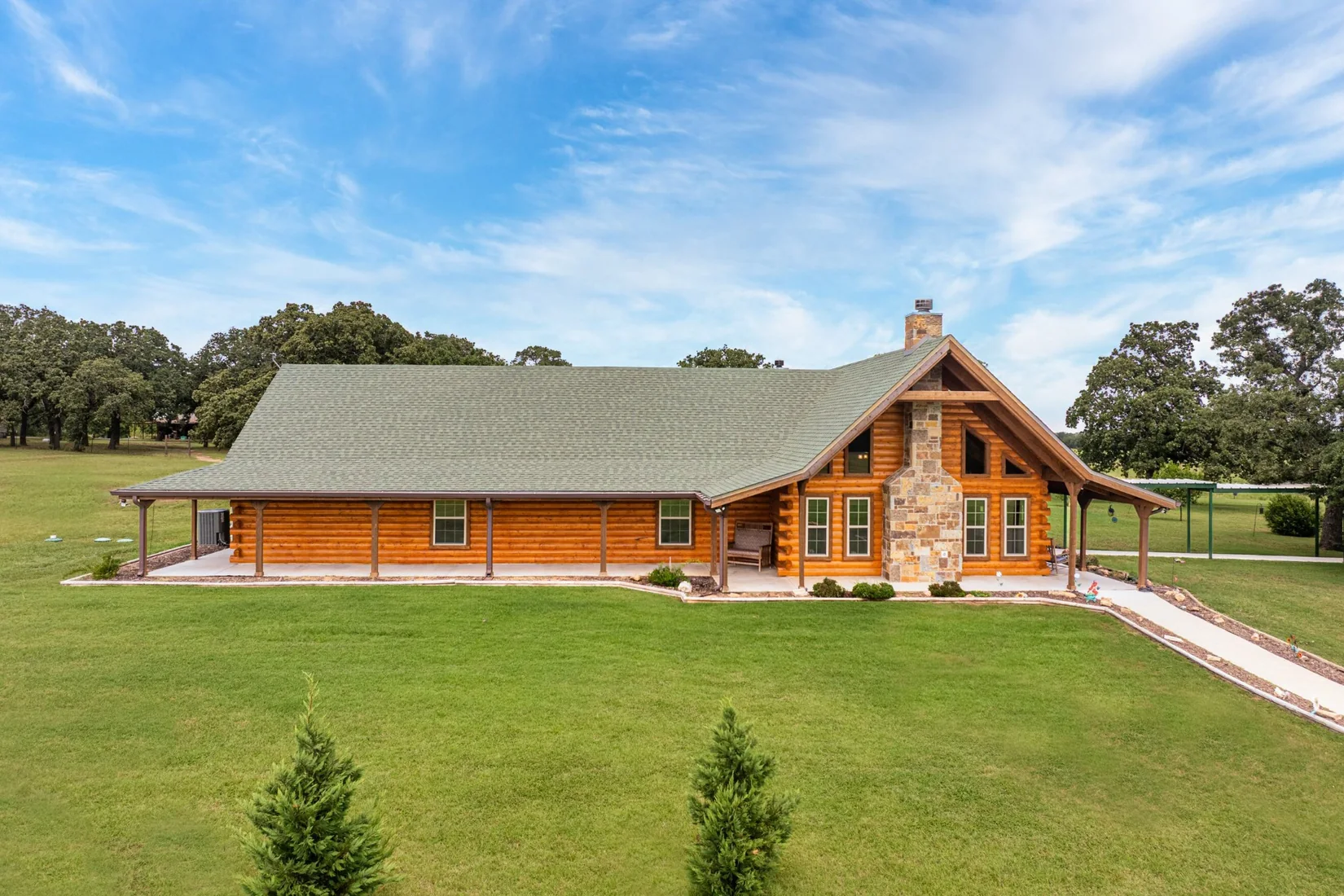 Genuine exterior photograph of a custom log home in Lipan, Texas